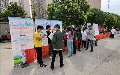 志愿者向群众发放宣传手册 志愿者向群众发放宣传手册