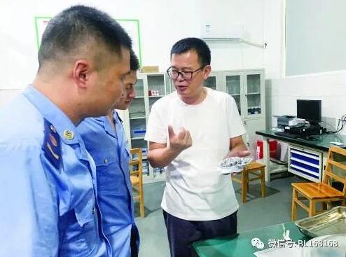 占松华（右）向市场监管局工作人员介绍研发技术。