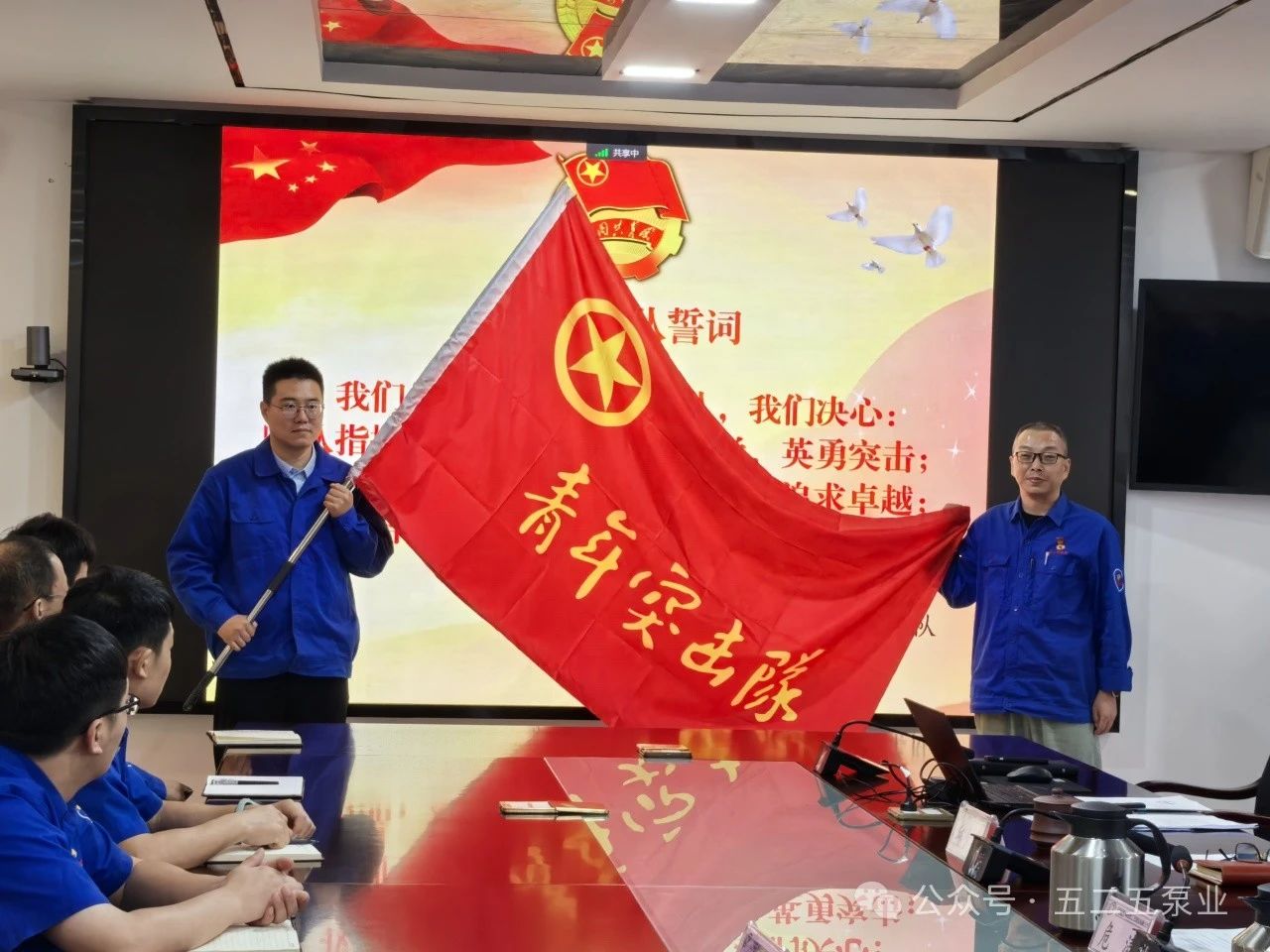 图为:危涛(右)为“兵工青年突击队”授旗 图为:危涛(右)为“兵工青年突击队”授旗