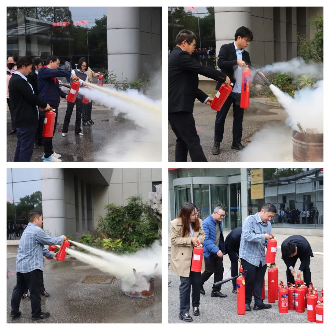 员工们手持灭火器参加现场灭火体验 员工们手持灭火器参加现场灭火体验